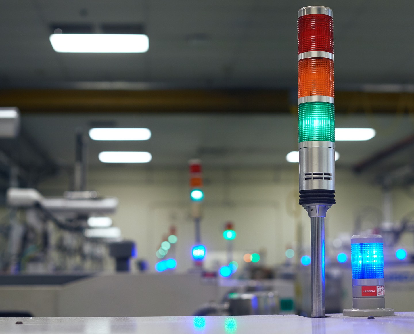 Close up image of a colored indicator light with factory in the background